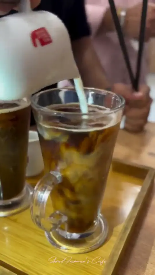 A tall cold coffee on the counter, then a rice bowl finished and served