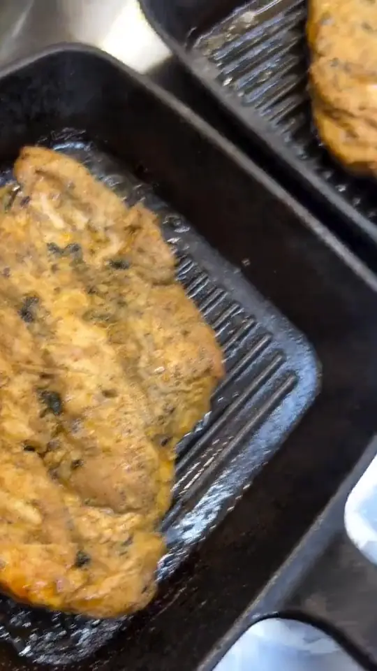 Marinated chicken fillets searing on the grill tray