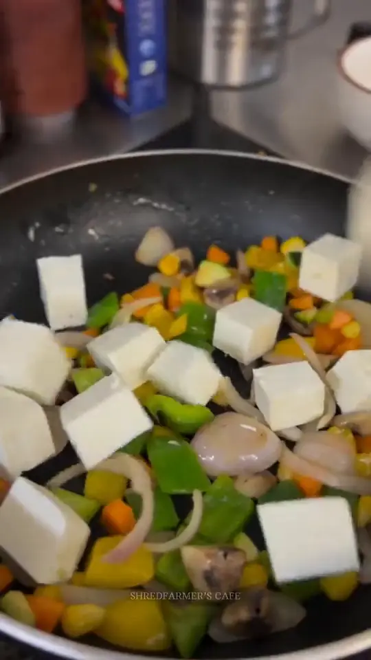 A paneer rice bowl being cooked off and tossed in the pan