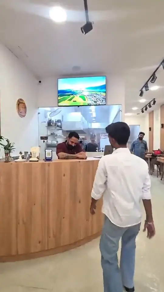 Walking in past the tables to the counter and the open kitchen behind it