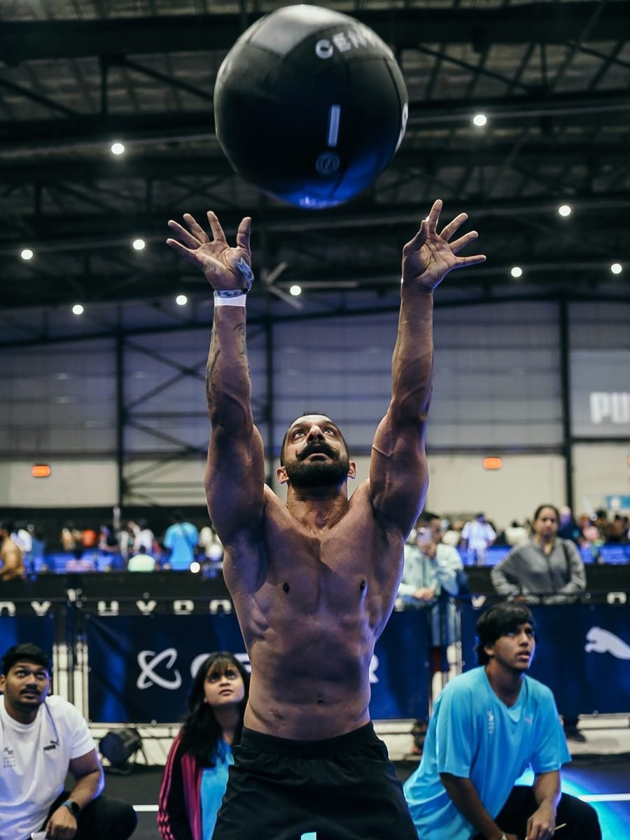 Satnaam throwing a wall ball overhead during a HYROX heat