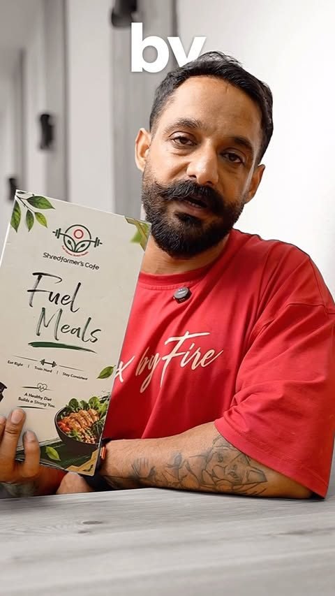 Satnaam holding the printed Fuel Meals menu booklet