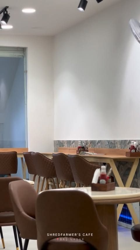 The dining room with tan leather chairs and marble-top tables