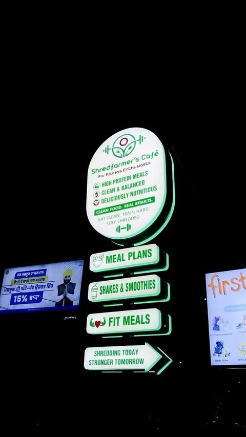 The lit Shredfarmer's Cafe sign at night in BRS Nagar, Ludhiana